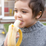 child eating a banana